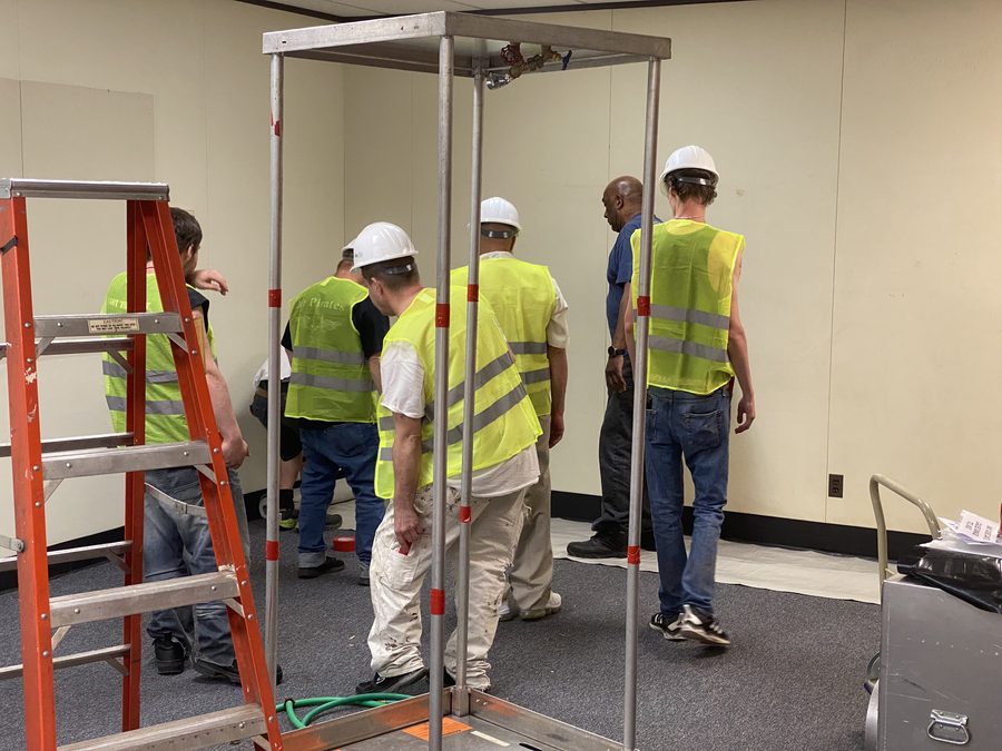 Crew at the work area with labeled asbestos disposal materials.