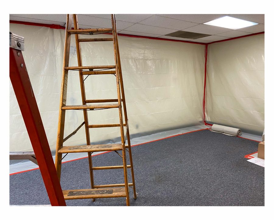 Sealing the room with poly sheeting before abatement practice.