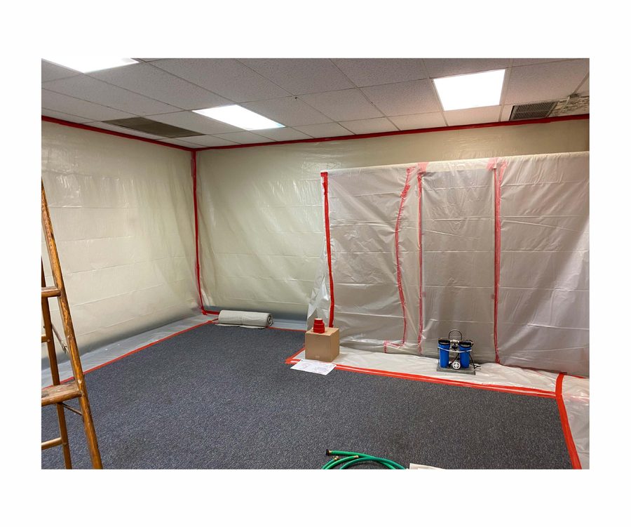 Negative-air machine and critical barrier installed in the work area.