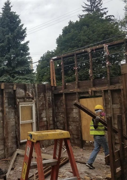 Taking the structure apart by hand to salvage framing lumber.